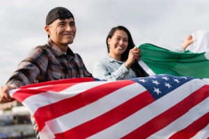 hombre y mujer sosteniendo banderas de estados unidos y mexico